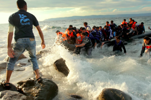 Refugiats sirians arriben a l’illa grega de Lesbos davant la mirada d’un membre de l’ONG IsraAid. Foto: Lior Sperandeo / IsraAid